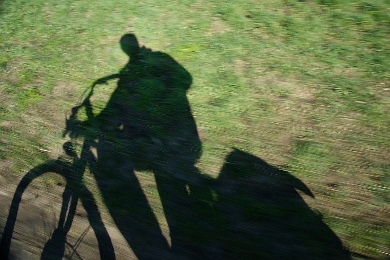 AH01.jpg - Leuk idee, om je eigen schaduw tijdens het fietsen te fotograferen. Door de langzame sluitertijd is het gras onscherp maar omdat camera en schaduw op dezelfde snelheid bewegen is de schaduw wel scherp.