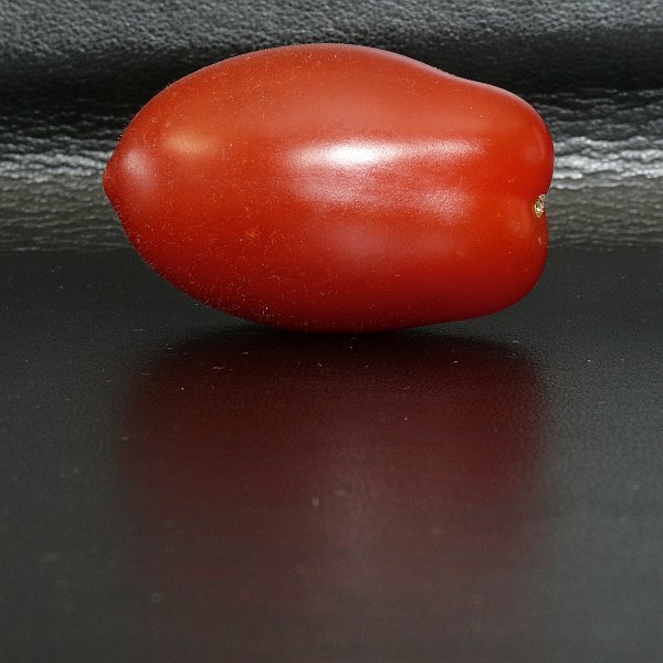 AJ02.jpg - Hij knalt er uit deze tomaat. Voor deze uitsnede had naar mijn smaak de reflectie iets sterker mogen zijn op de ondergrond.