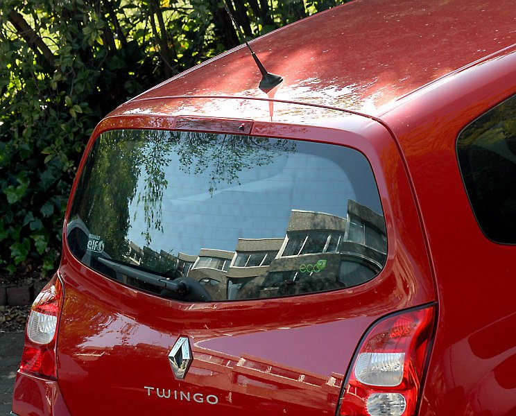 AM03.jpg - De foto van de rode auto is mooi, maar de weerspiegelingen van de eurowoningen in z'n lak en achterruit hebben ook iets bijzonders.
