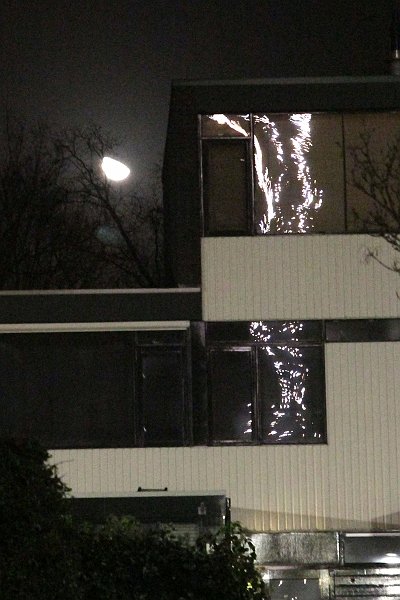 AP02.jpg - Een apart effect de feestverlichting spiegelend in de ramen van het huis en de maan er boven.