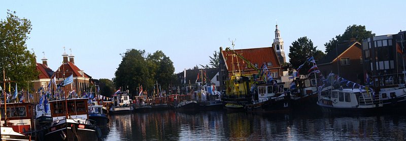 AM01.JPG - De boten in het water zijn iets te donker, door de lichte lucht is hier echt een belichtingscorrectie van ongeveer +1 nodig. Ook jammer is dat hier de horizon wel erg scheef loopt. Terwijl je juist aan bijvoorbeeld de toren voldoende houvast hebt om te zien of alles recht staat.