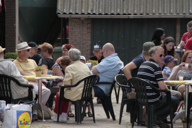 AB02.jpg - Een gezellig vol terras. Goede scherpte en belichting. Persoonlijk zou ik hebben geprobeerd om geen halve gezichten in beeld te hebben.