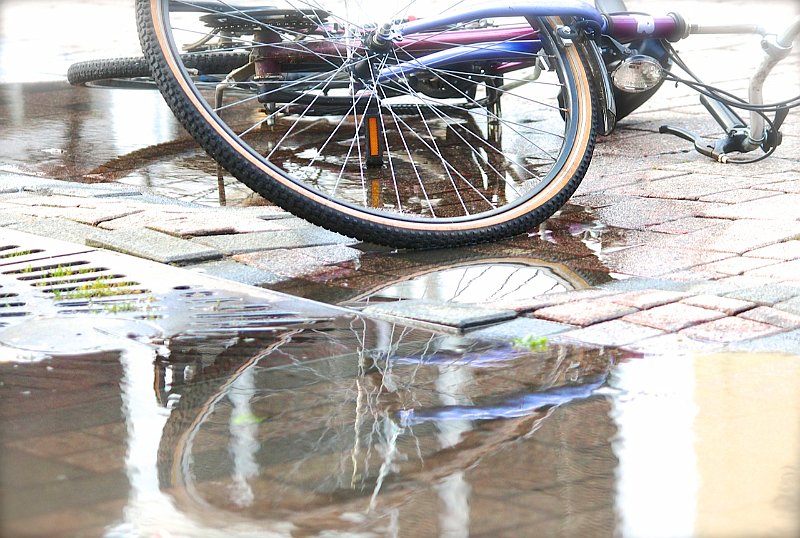 AD03.jpg - In eerste oogopslag lijkt de foto te licht, maar de fiets is werkelijk perfect belicht. Het lichte komt vooral door de reflectie op alle natte stenen en in de plassen. Hele mooie foto.