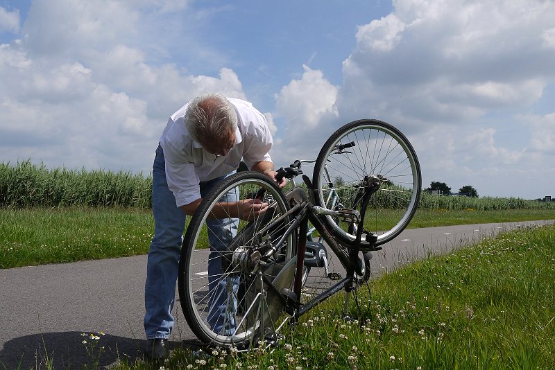 AI01.JPG - Dan is opeens de straat minder leuk als je er een lekke band krijgt. Goede belichting en scherpte. Als je de man met fiets meer tegen de linkerkant had gezet had je rechts de weg nog veel langer laten worden zowel in beeld als symbolisch.