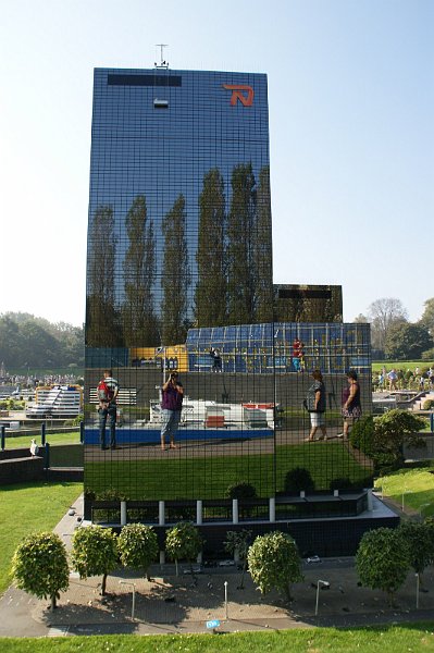 AD01.JPG - Moderne architectuur in het klein. Alleen al die spiegelende mensen er in is apart. Ik denk dat als je de foto meer had in gezoomd zodat links en rechts van het gebouw er geen Madurodam te zien zou zijn geweest, het beeld nog aparter zou zijn geworden.